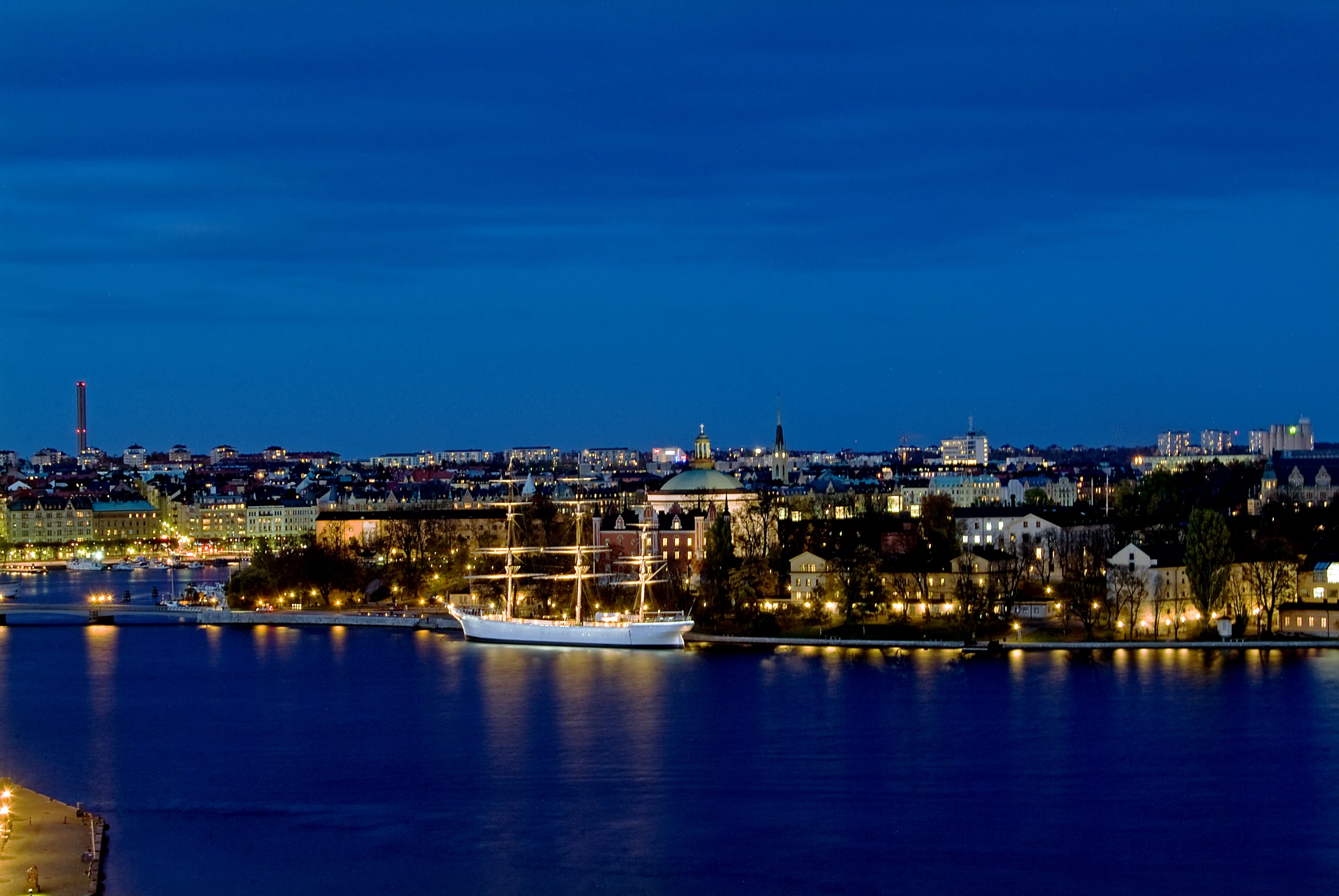 the city lights reflecting on the water at night