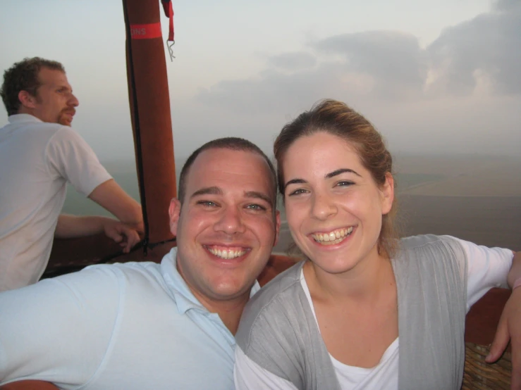 two people posing for the camera with a sky background