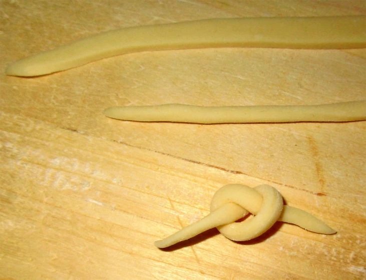 three scrunched bananas on a wooden surface