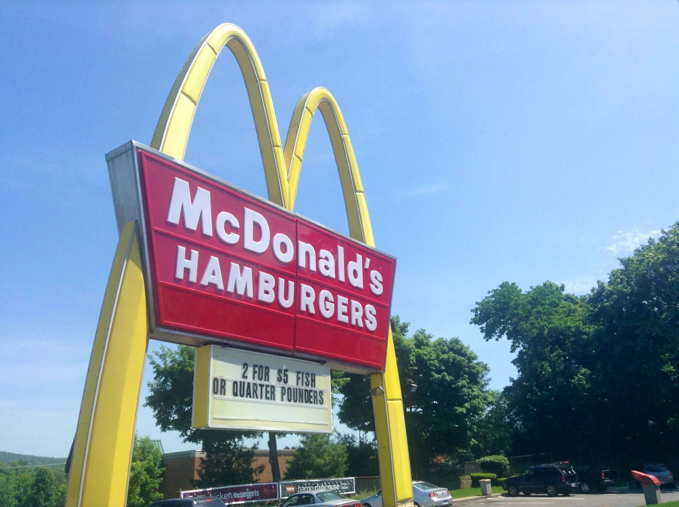 a sign for a mcdonald's hamburgers sitting on a street