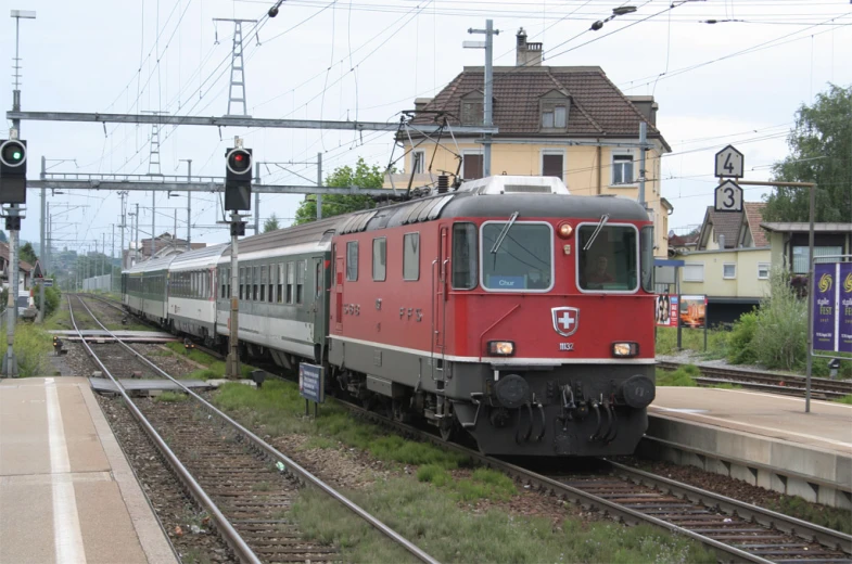 a train on a track with buildings and traffic lights