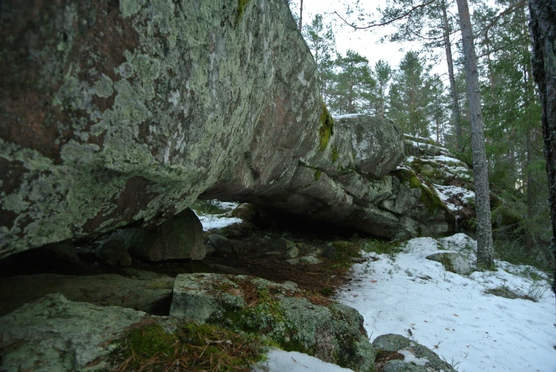 rock formation with snow and trees behind it