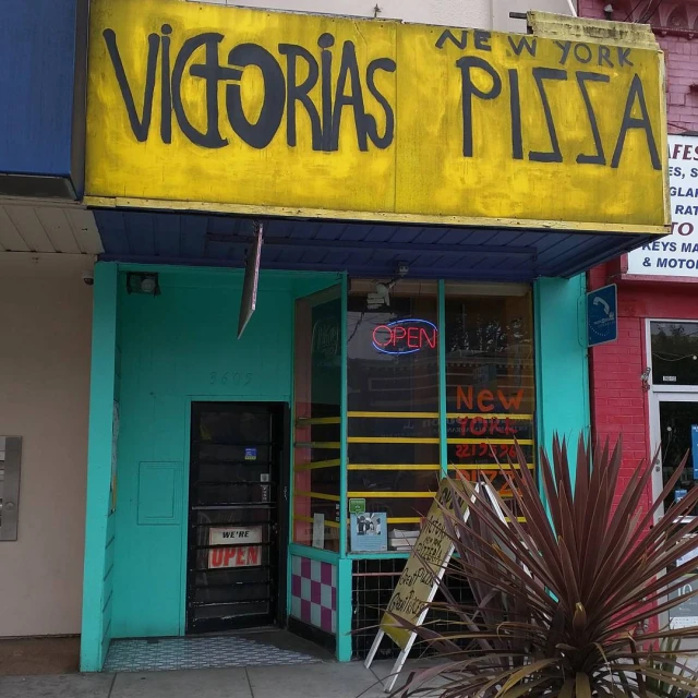 a large sign that says victoria's pizza with a colorful background