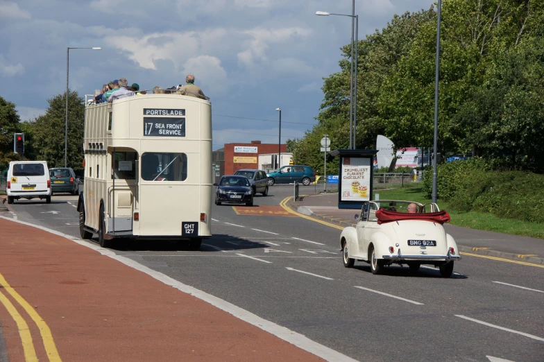 cars driving down the road as an open top bus pulls up