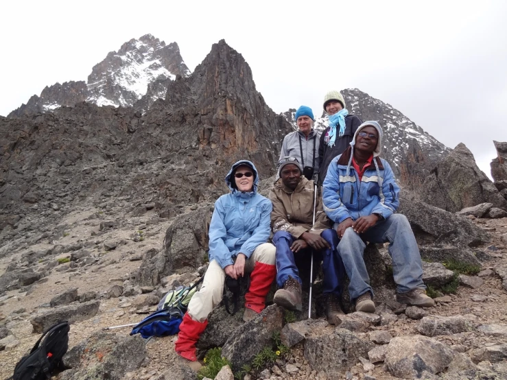 a group of friends sitting on top of a mountain