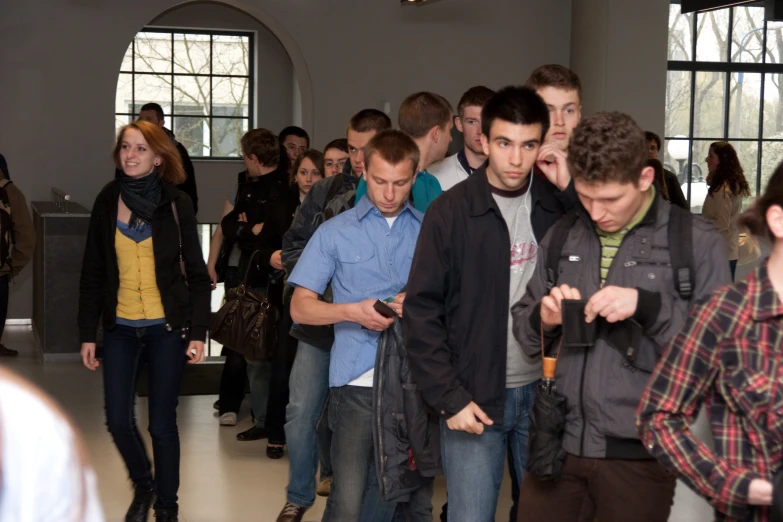 a group of people standing in a room looking at soing