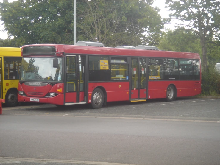 two large red buses parked next to each other