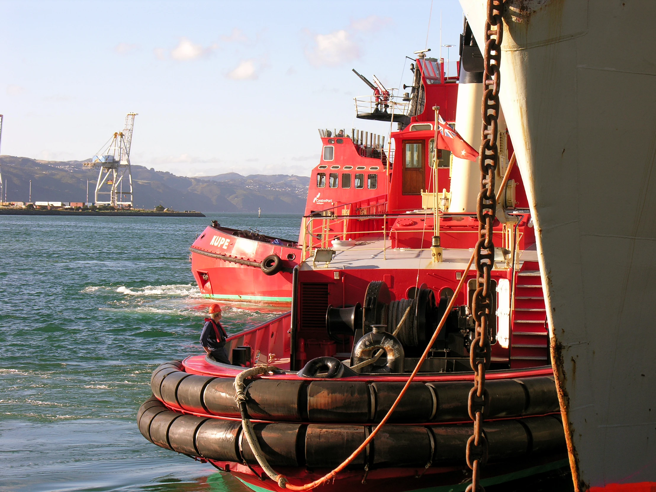 two large red tug boats in the water