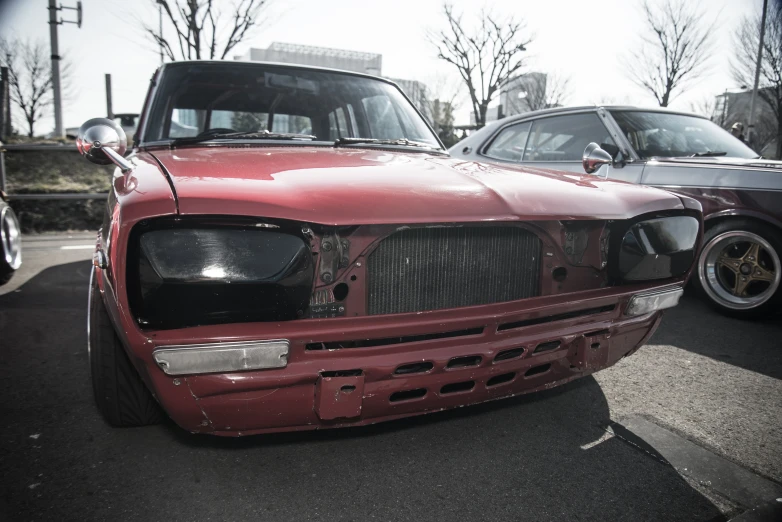 the front of an old red car with some parts missing