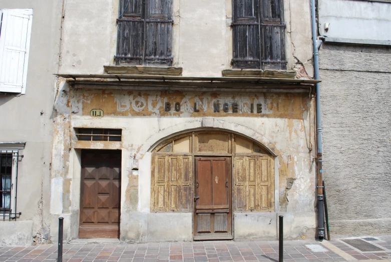 a building with boarded up windows has brick floors