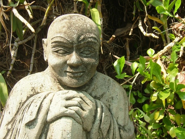 a statue of buddha in front of trees