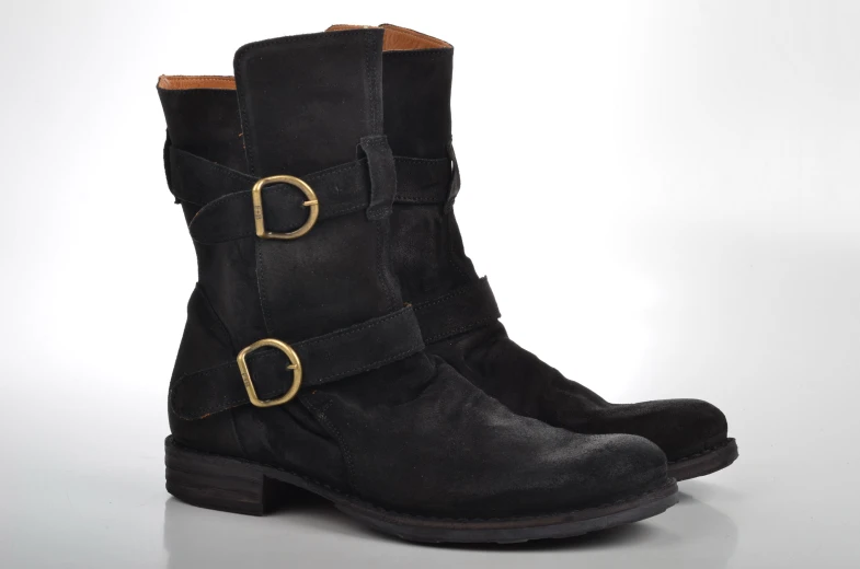 black boots with gold buckles and a white background