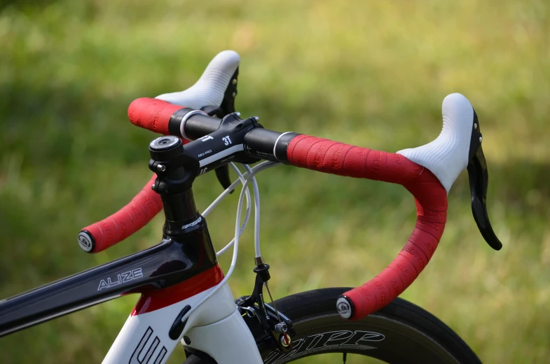 the handlebars of a red and white bicycle