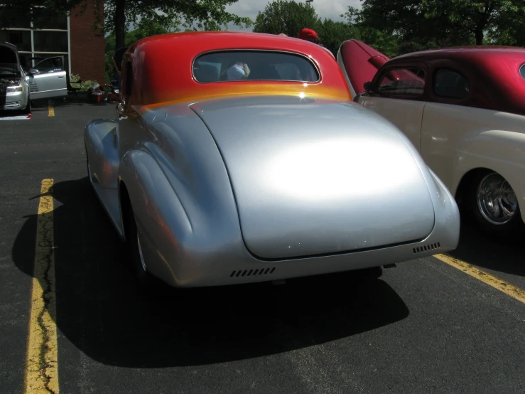 silver and red car in parking lot with other cars