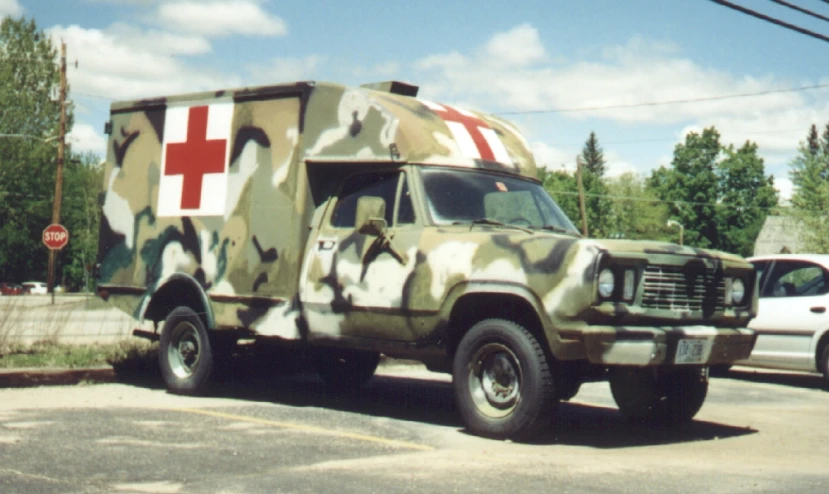 an army camo truck and a white pickup truck parked next to each other