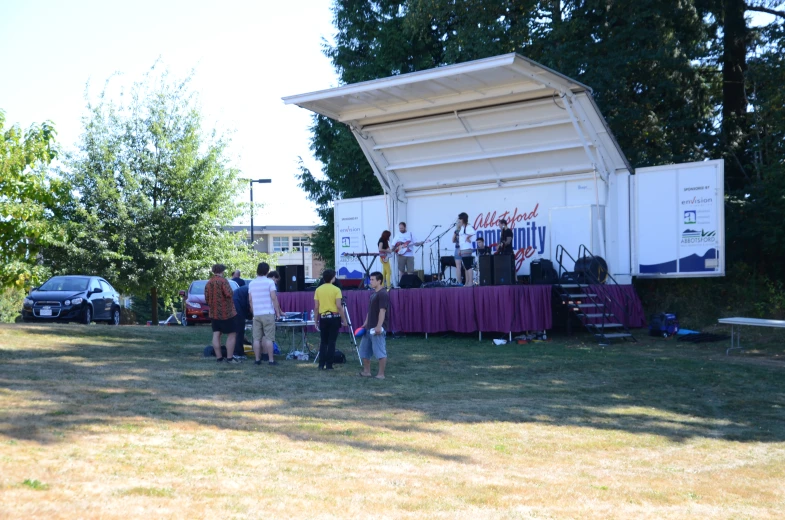 several people watching as a band plays at a concert