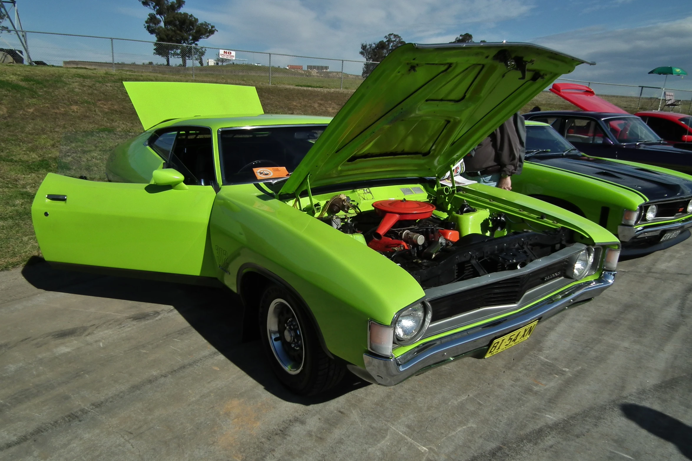 two different color cars that have their hood open