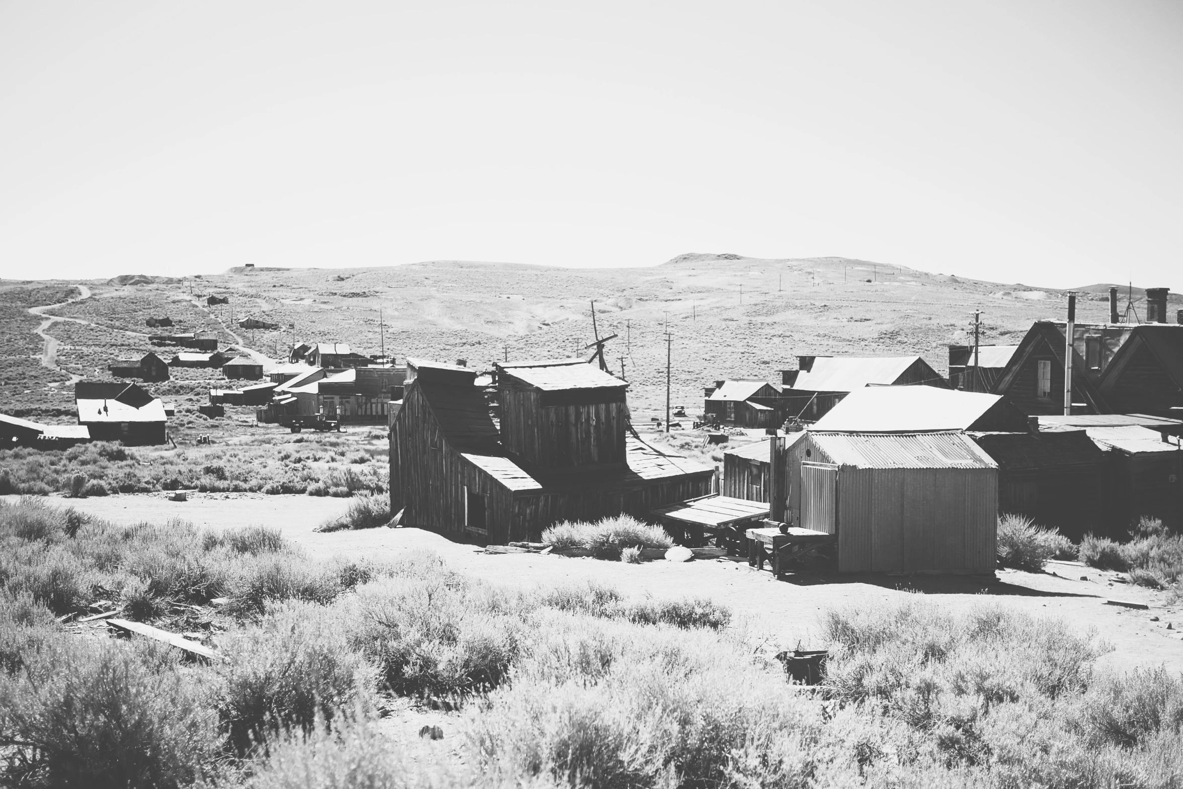 black and white pograph of several shacks on a hillside