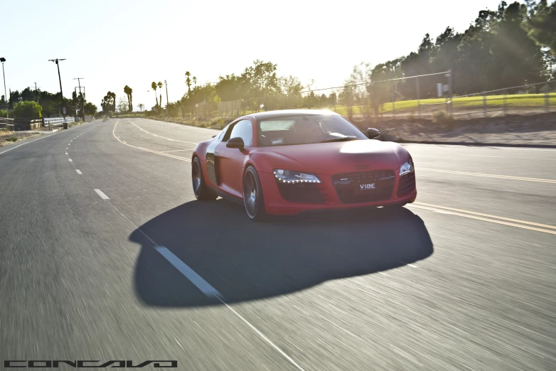 a red sports car is driving down a street