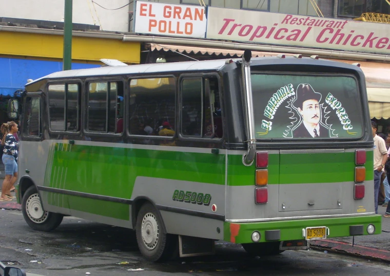 green and gray bus with a logo on the front