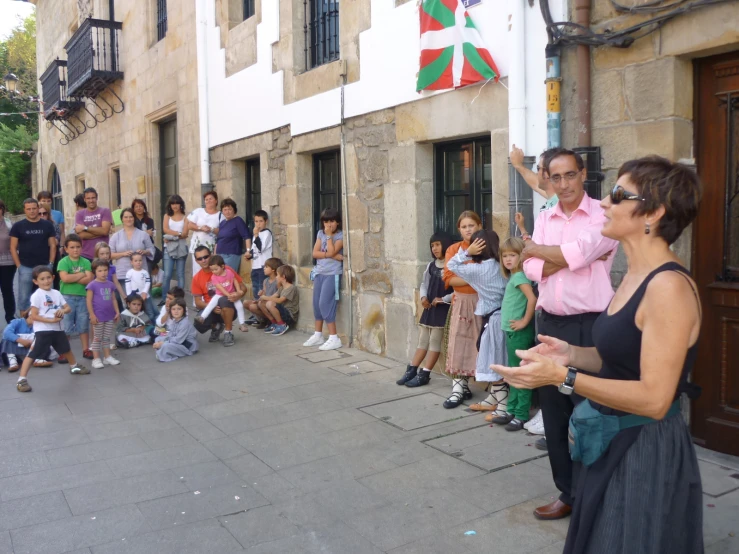 a group of children on the side walk watching people pass by