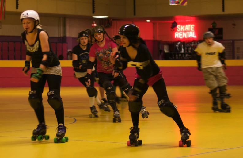 a group of girls rollerblading inside a building