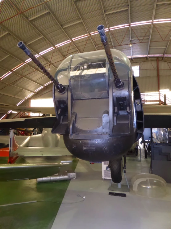 an old military plane sits inside a hangar