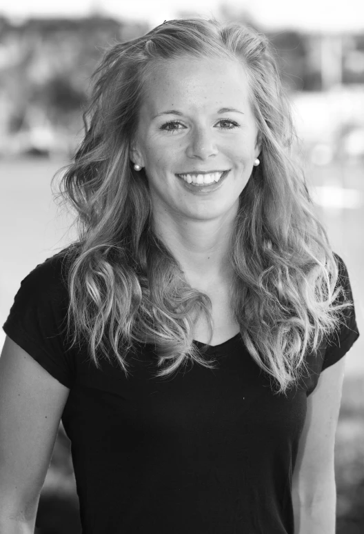 a woman with blond hair standing smiling