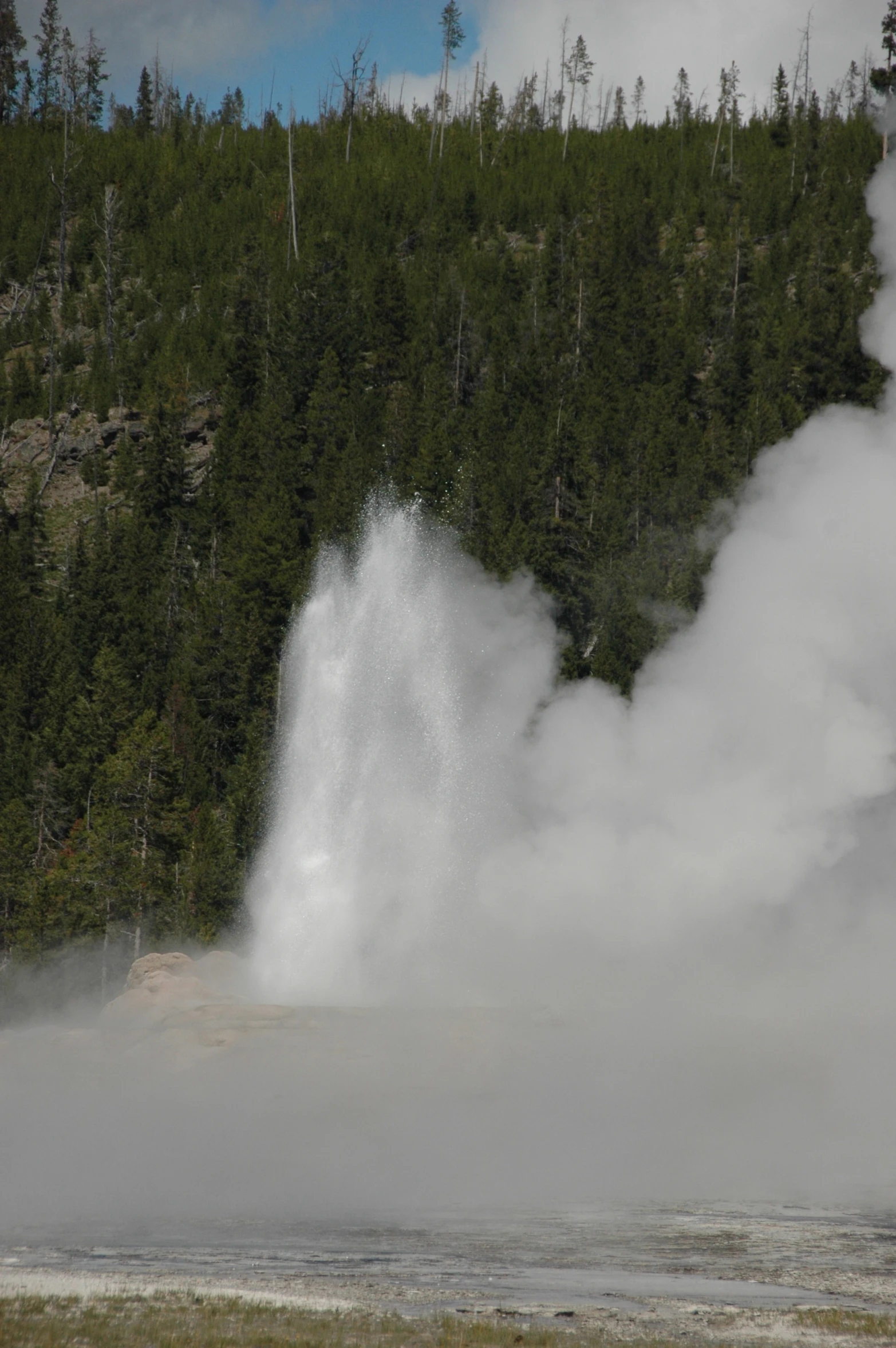 a group of steam rises from a geomical hole in the ground