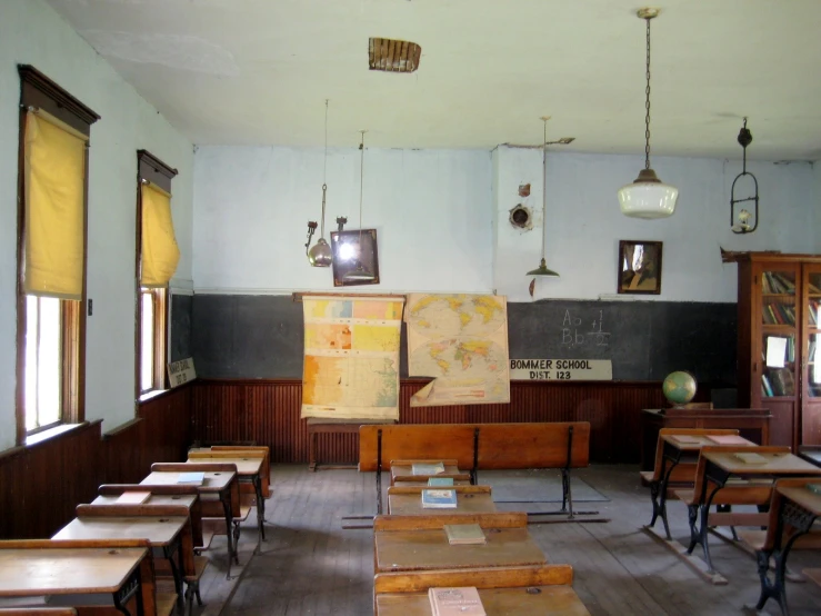 an empty classroom with desks and windows
