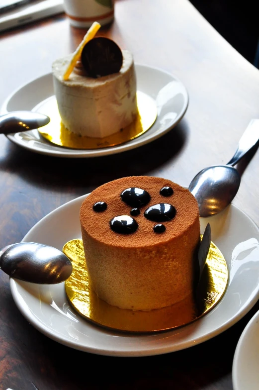 two plates of cake on a table with spoons