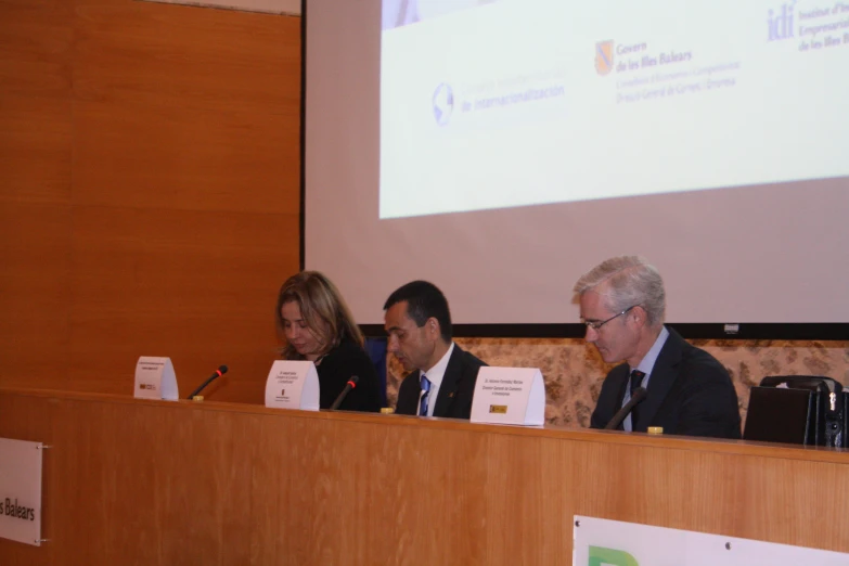 a panel of three people sitting at a podium