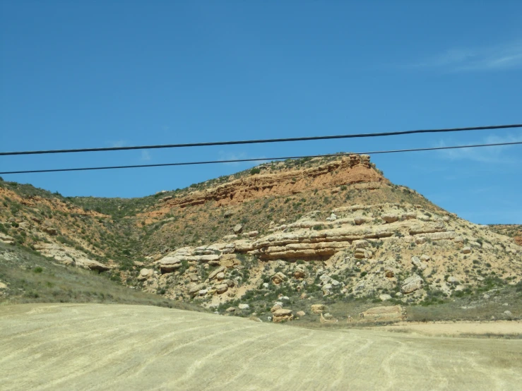 a view of a hill with two large mountain in the background