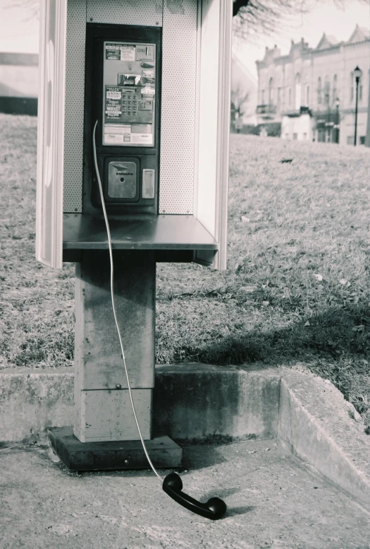 a telephone booth sitting on the side of a road