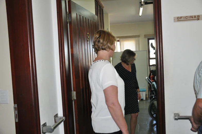 two women are seen standing by the entrance to the building