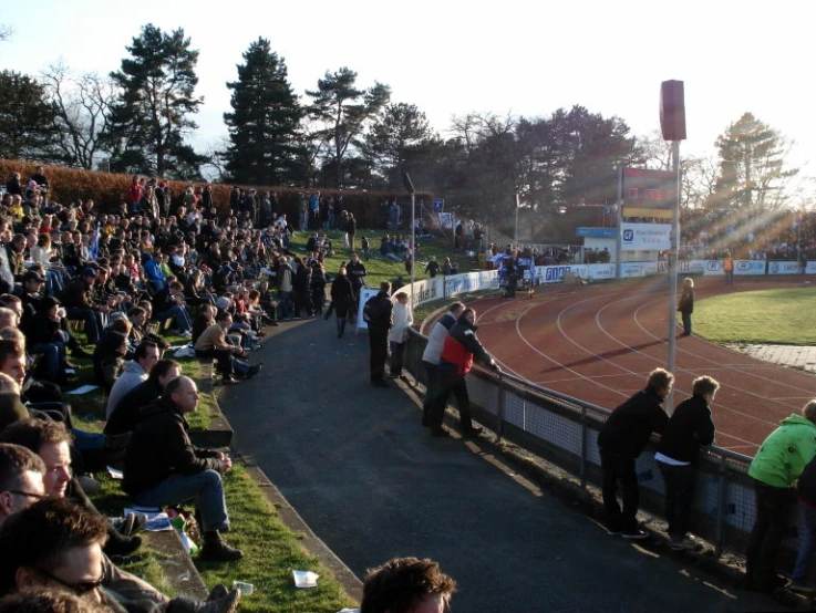 a crowd of people on a sports track watching soing