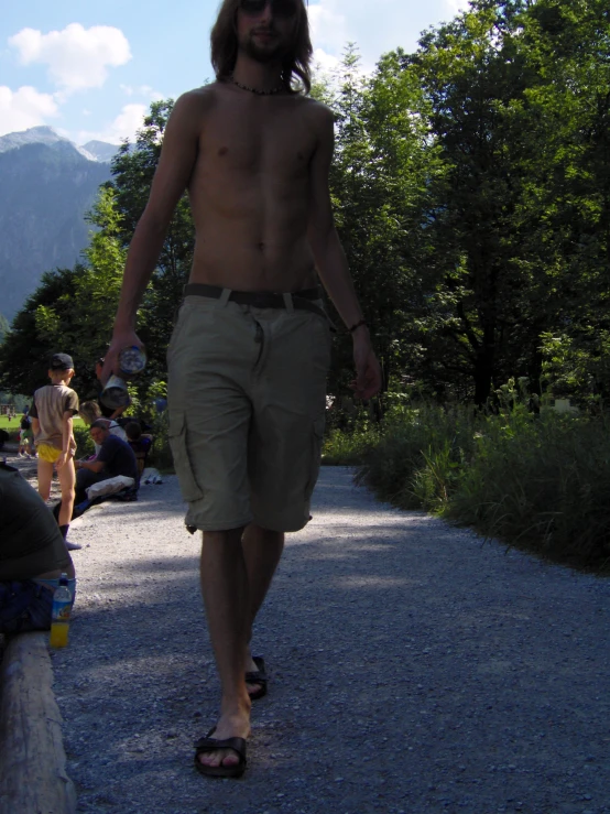 man wearing  and short walks down a dirt road