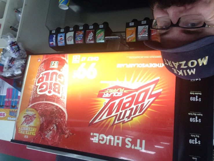 a man with a baseball cap standing next to a vending machine