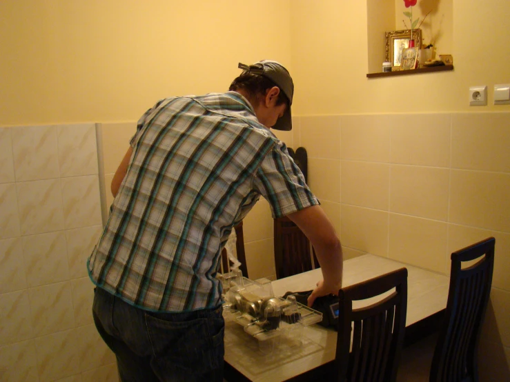 man standing over table preparing to use a cordless drill