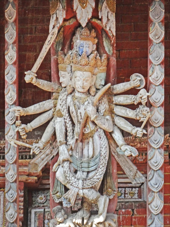 a carved statue on display with many objects in front