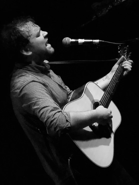 black and white pograph of a man with an acoustic guitar