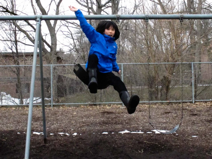 a child playing on a swing at the park