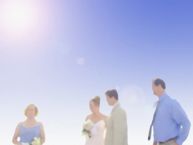 a group of people walking across a grass covered field