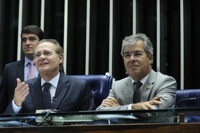 three men in suits, one in grey, the other in black