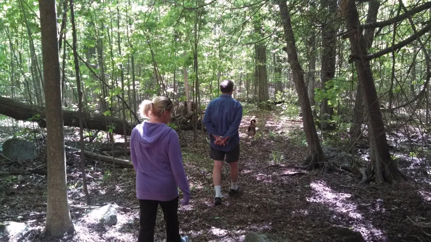 two people in the woods walking on a path