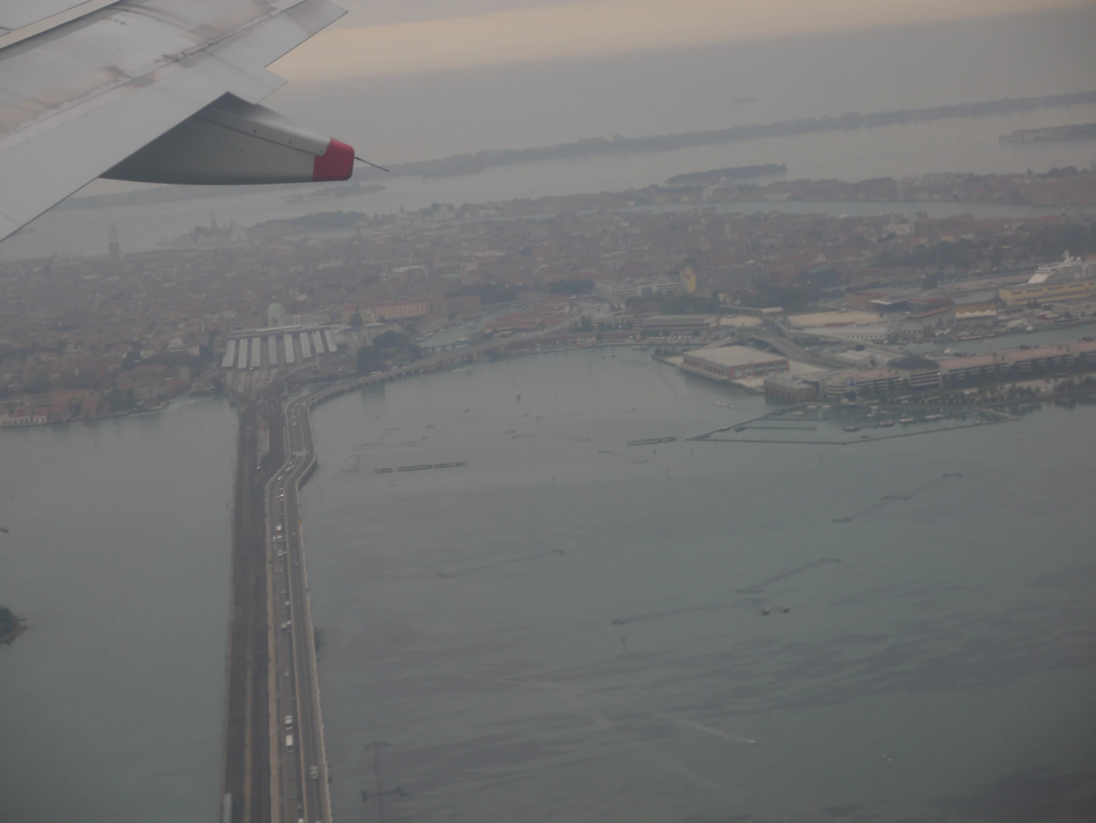 an airplane wing is flying over a waterway