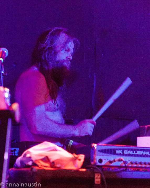 man playing drums while wearing long underwear at a concert