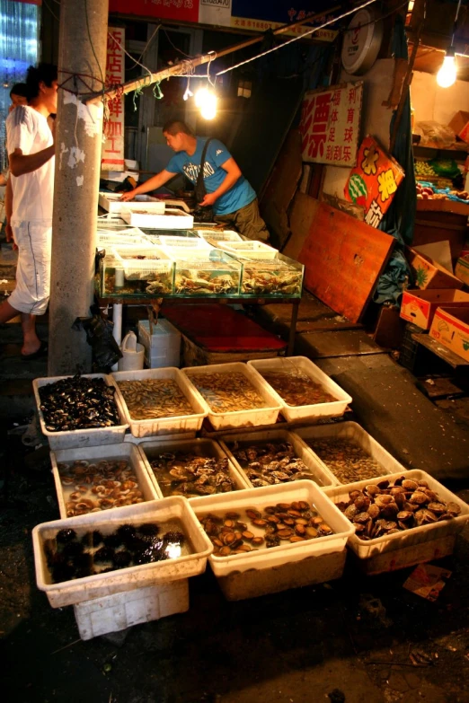 people shopping in an asian market with lots of boxes full of food