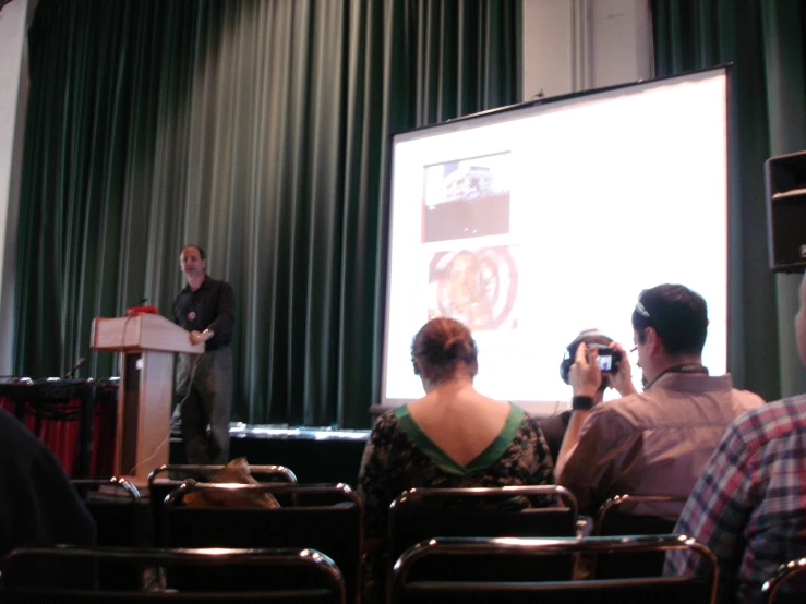 a woman standing in front of a projection screen