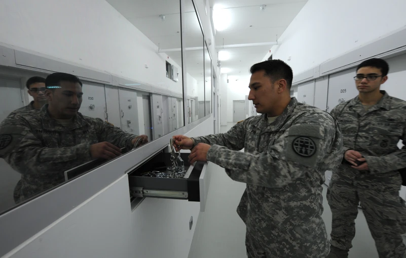 a couple of men in uniform looking at items